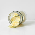 Glass jar with sliced freeze dried limes on a white background