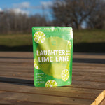  'Laughter Lime Lane' package on a wooden surface with a blurred natural background
