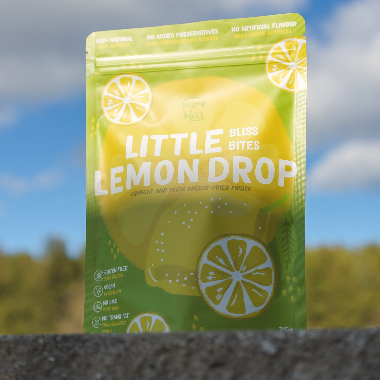 Packaging of Little Lemon Drop Bliss Bites with a blurred outdoor background