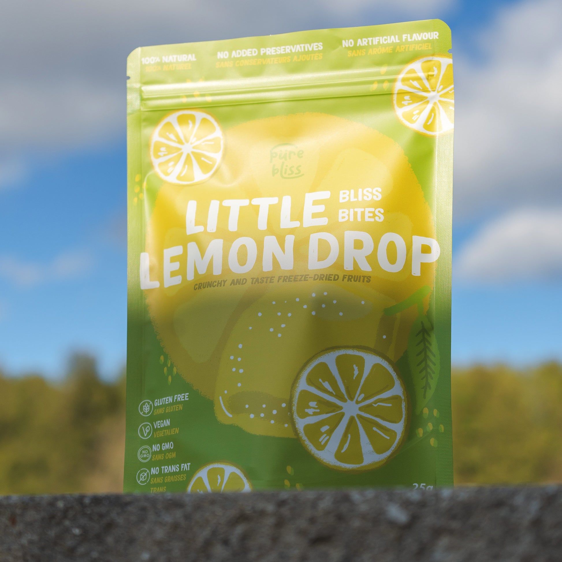 Packaging of Little Lemon Drop Bliss Bites with a blurred outdoor background